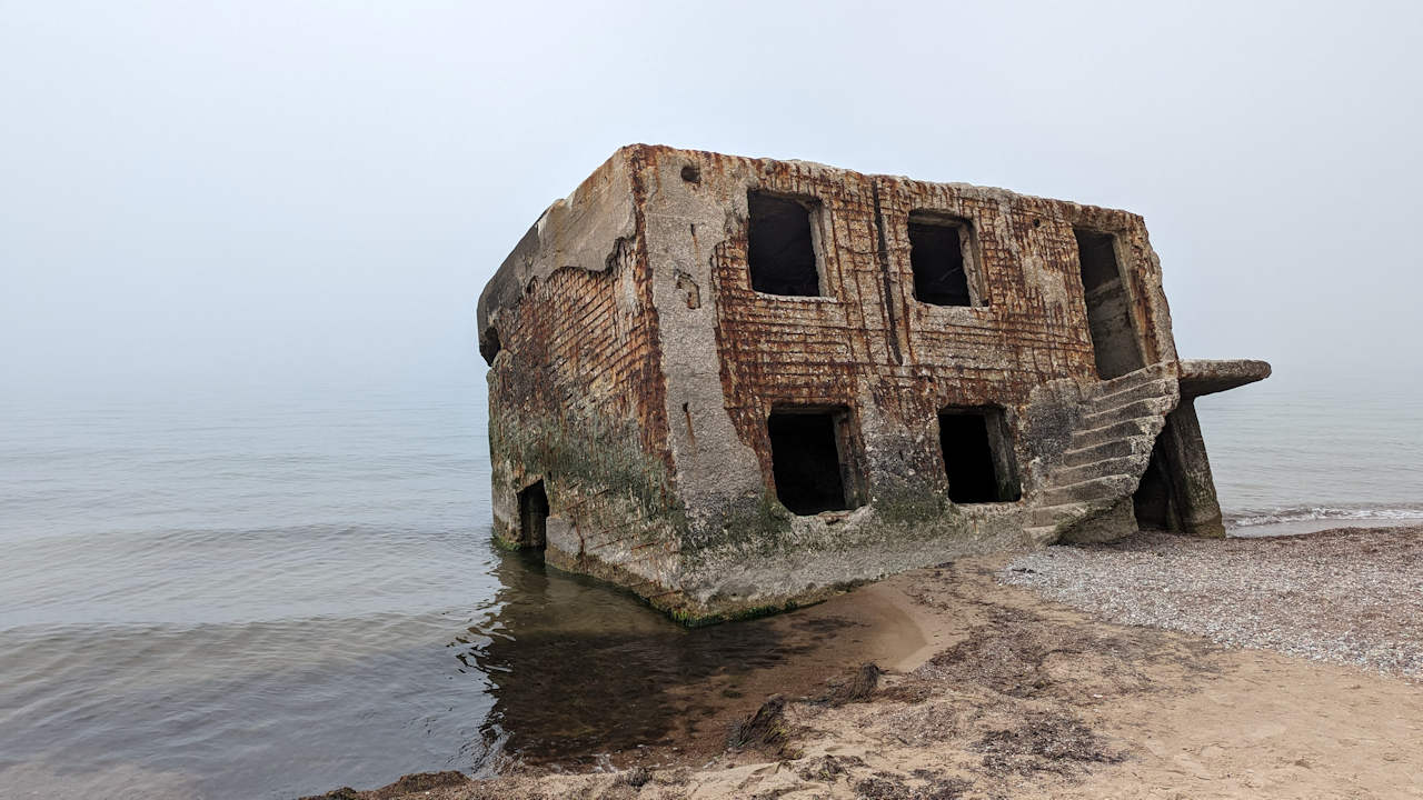 Schief stehender und stark korrodierter Bunker in Karosta, der ins Meer gerutscht ist. 
