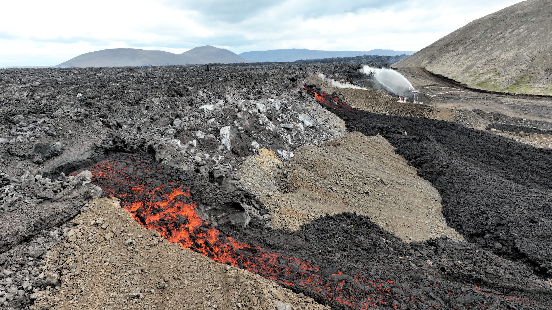 Glühende Lava läuft beim Svartsengi Kraftwerk über einen Schutzwall