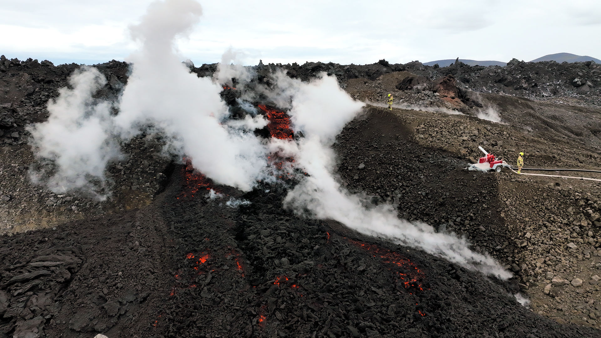 Weisser Dampft steigt von glühender Lava auf, die mein Svartsengi Schutzwall über die Barriere läuft. 