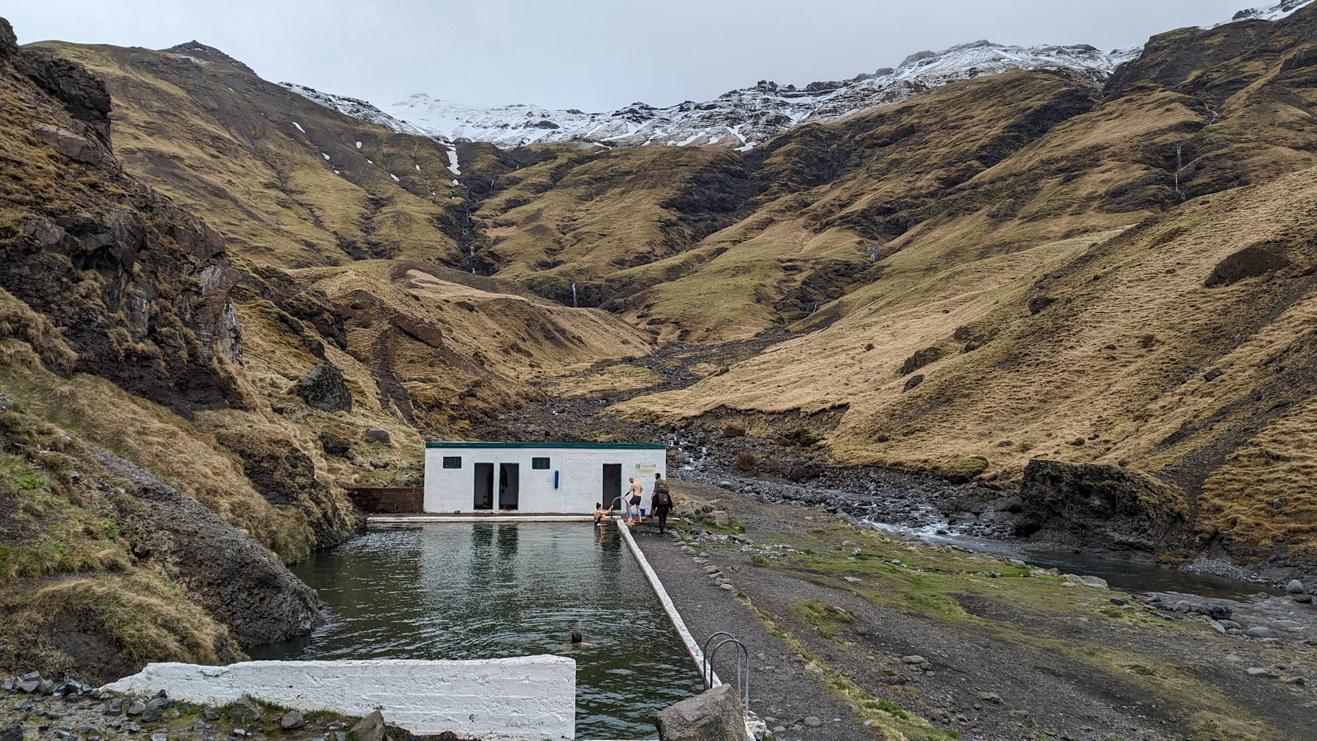 Seljavallalaug Island eingebettet in Berge mit schneebedeckten Spitzen