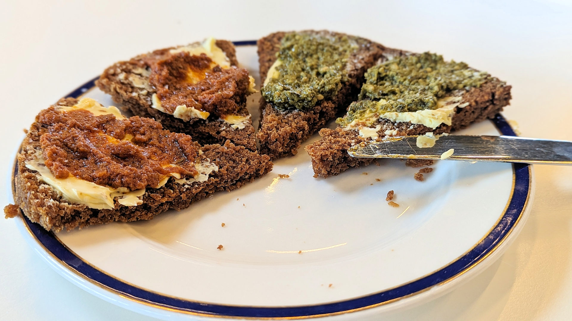 Vier Stücke in der heissen Erde von Island gebackenes Brot mit Butter und Pesto bestrichen 