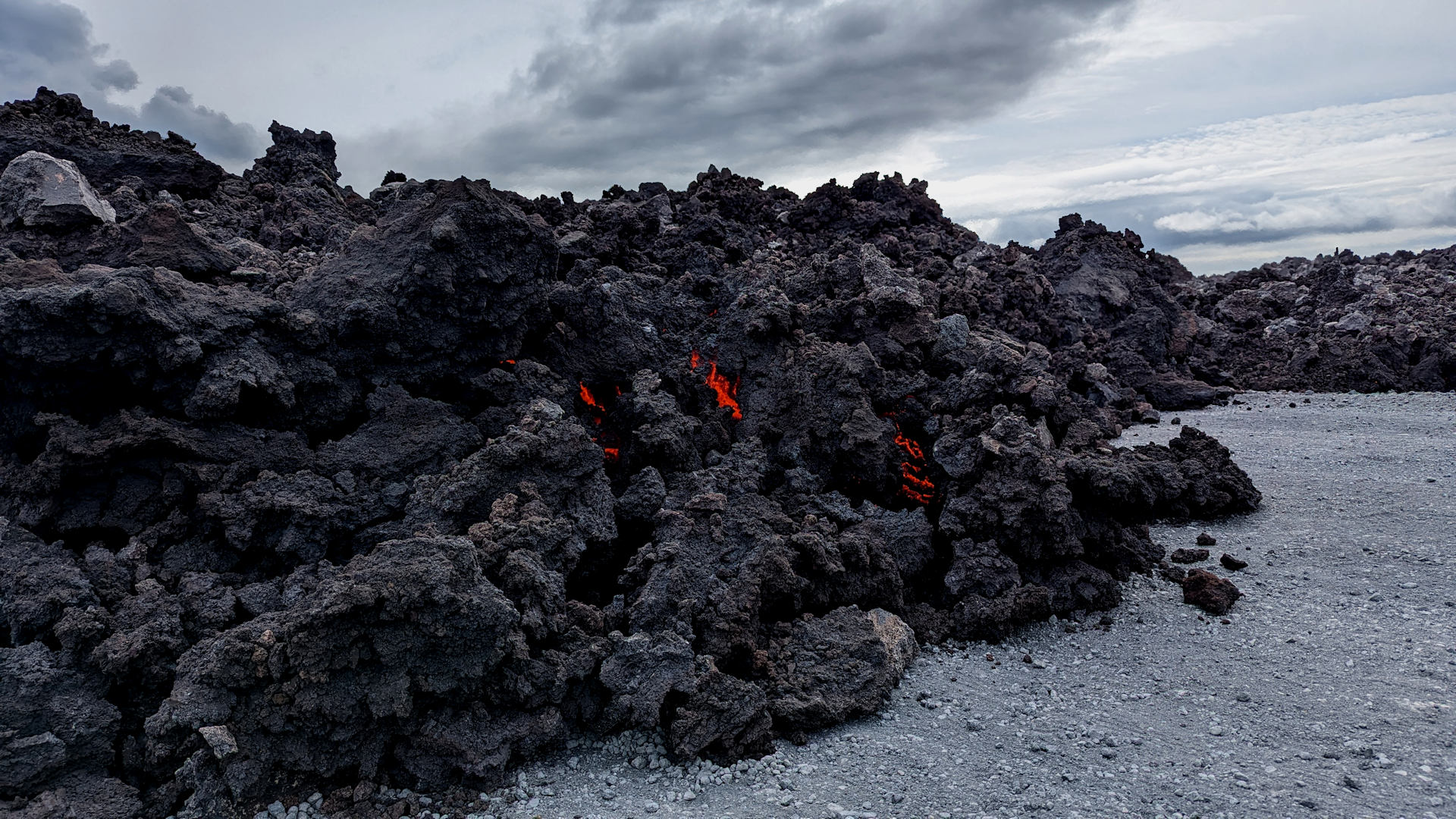 Schwarze Lava die innen rot glüht hat die Road 43 in Grindavik erreicht und überrollt. 