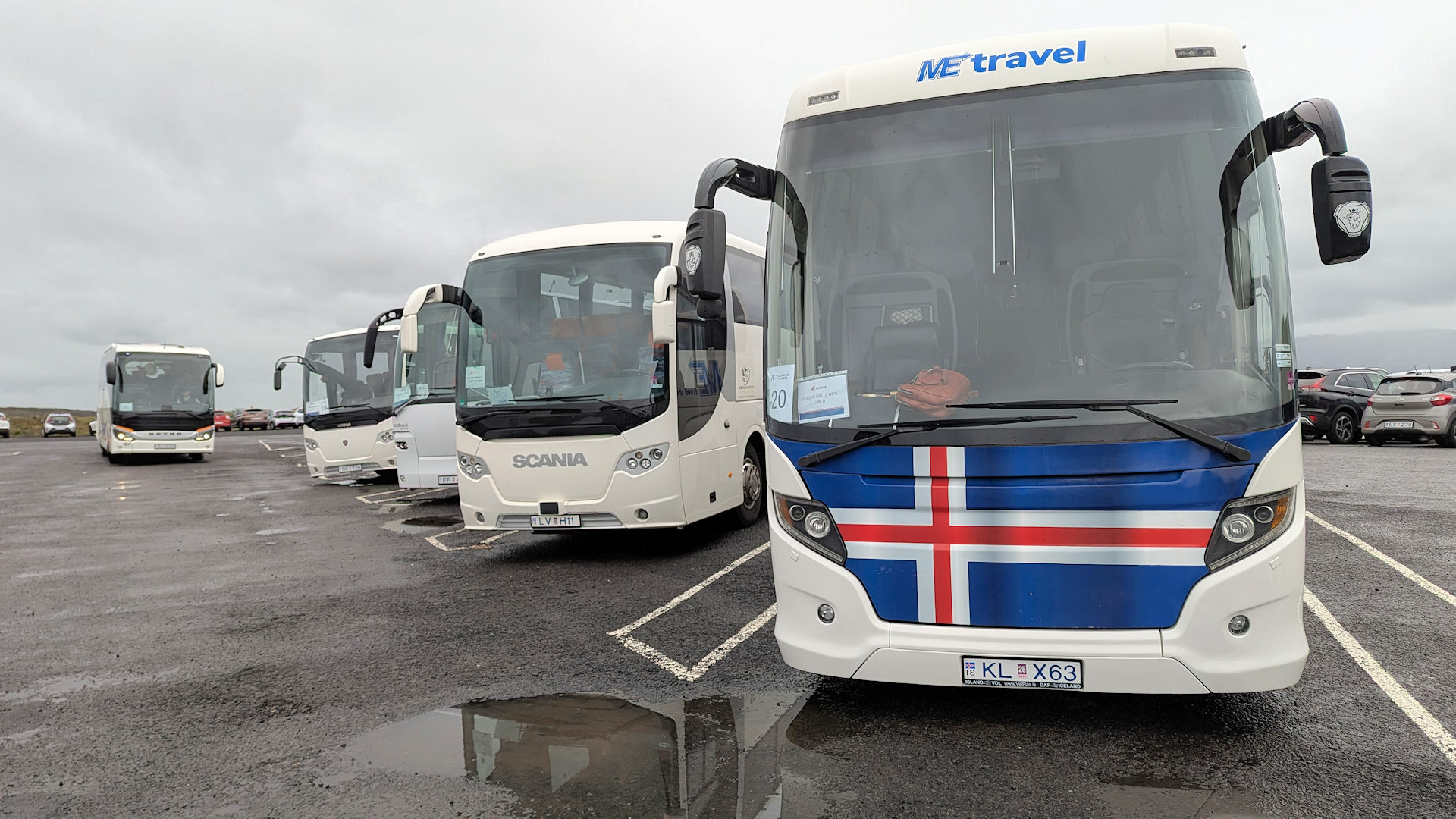 5 Reisebusse auf einem Parkplatz in Island