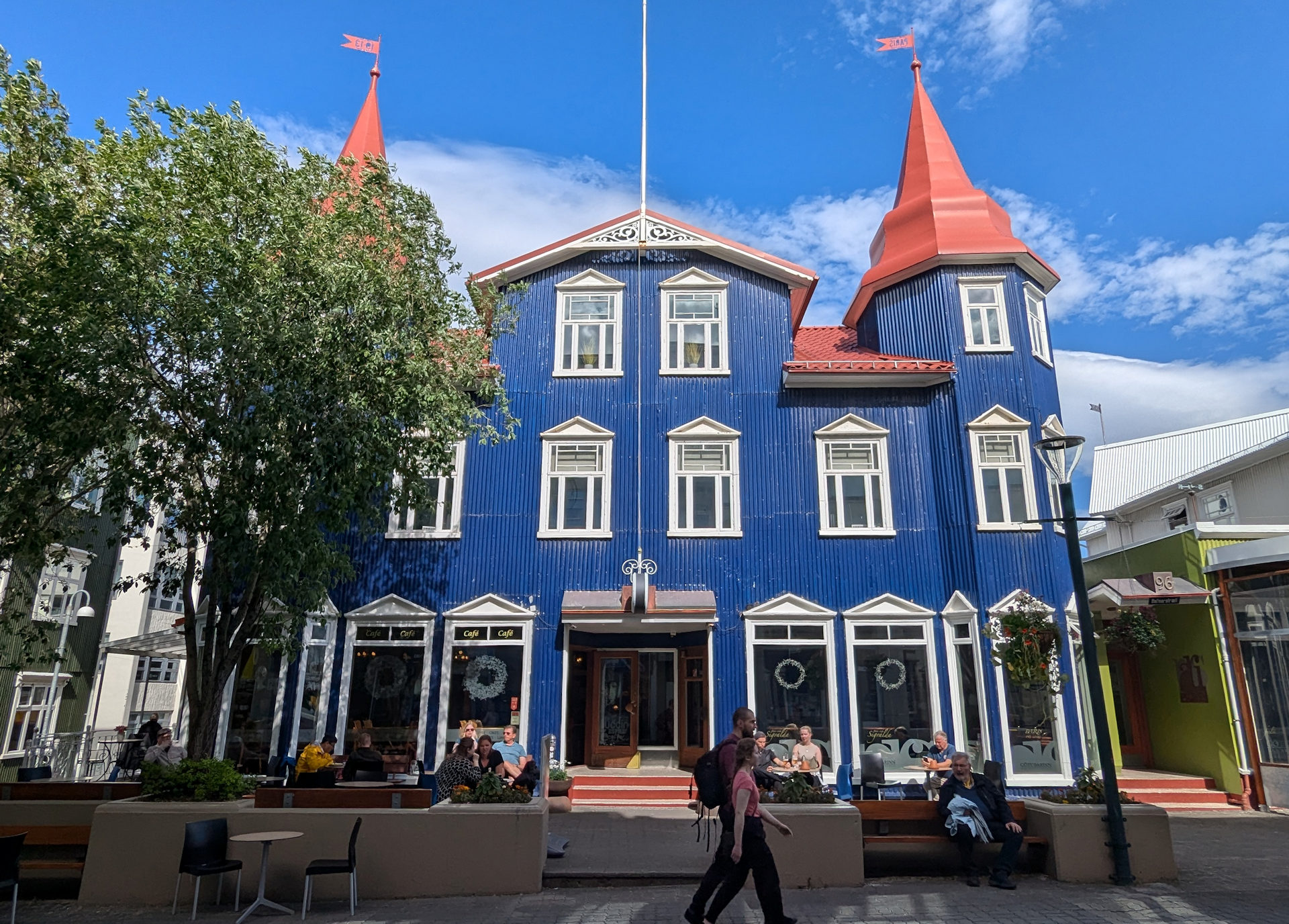 Cafe Blaue Kanne in Akureyri von aussen fotografiert. Ein blau angemaltes Haus mit rotem Dach. 