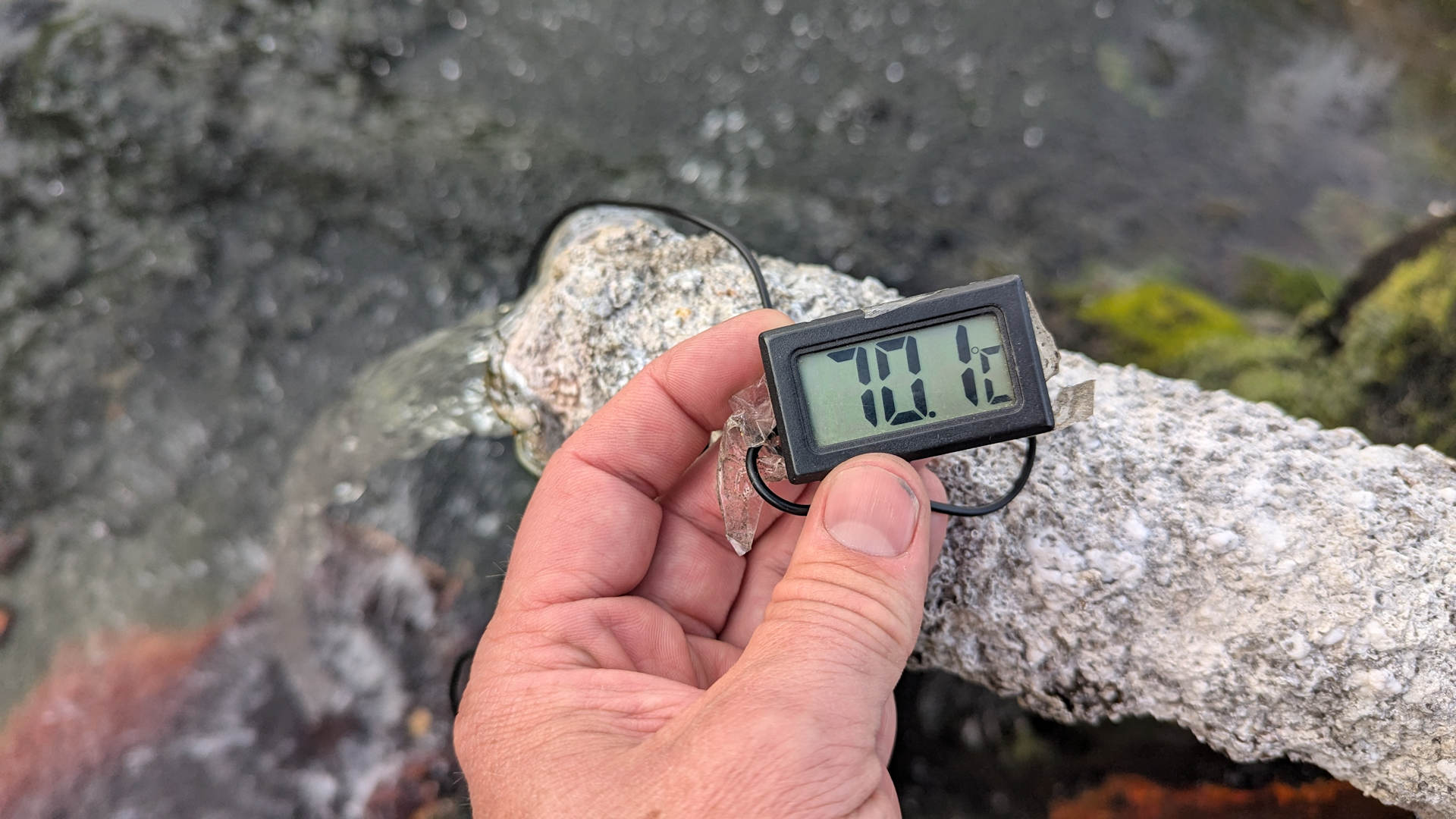 Ein Thermometer zeigt 70 Grad an einer heissen Quelle in Island an