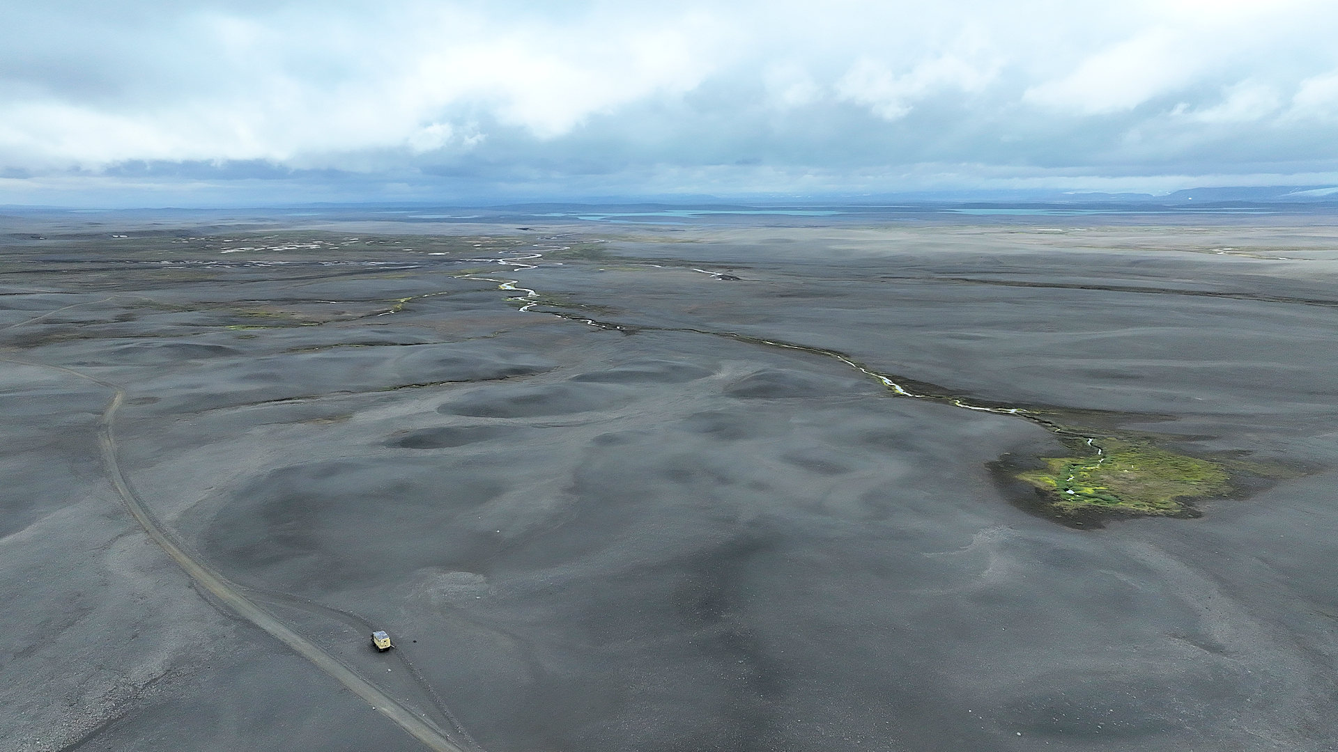 Drohnenaufnahme vom grauen Island Hochland mit grüner Vegetations Insel 