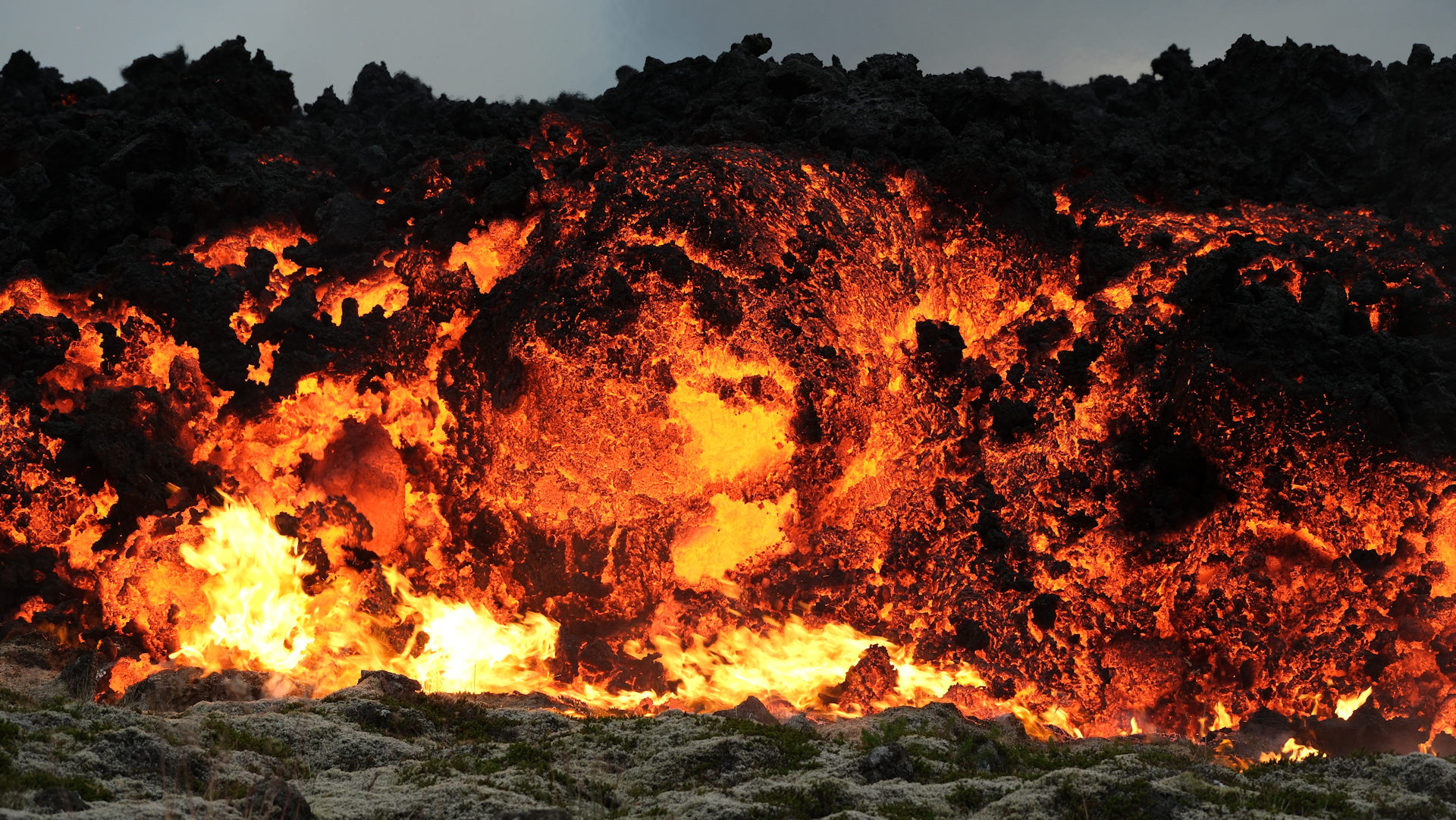 Glühende Lava wälzt sich über Moos in Island