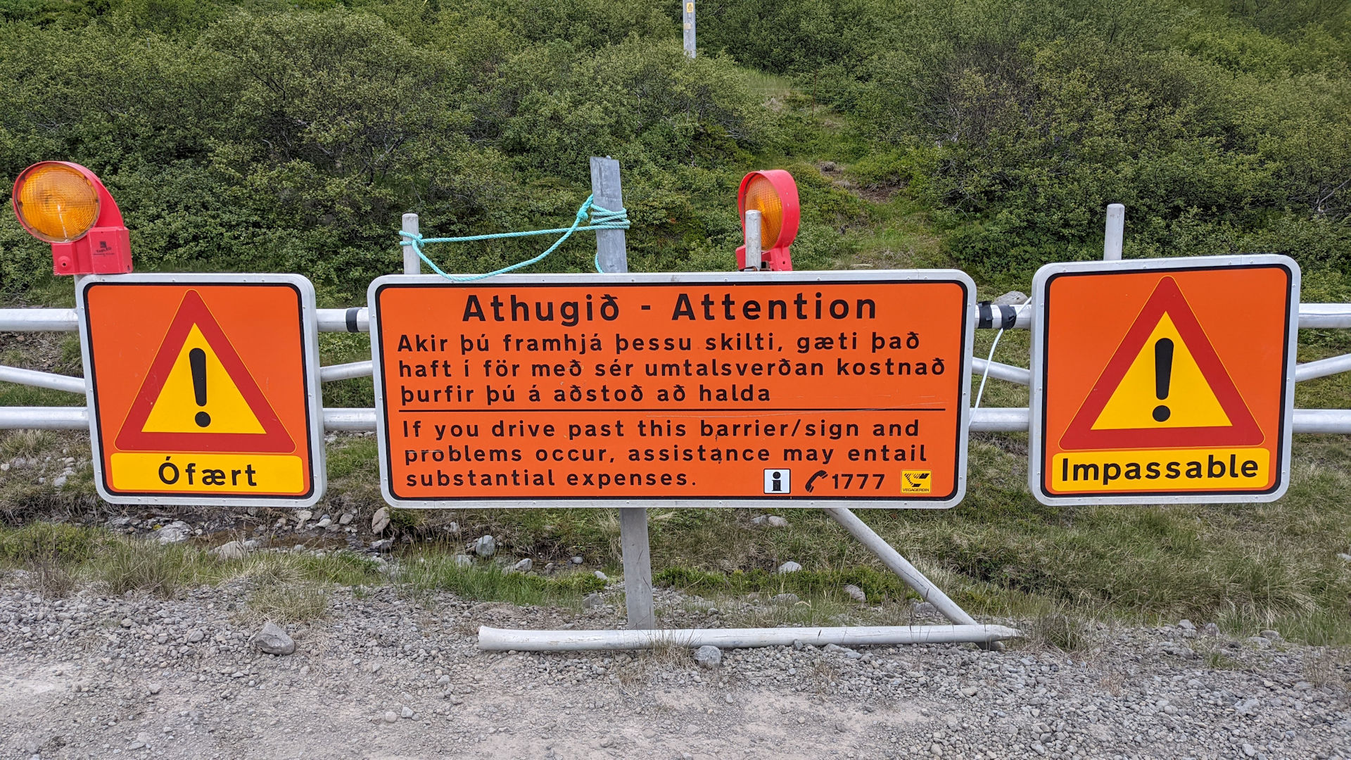 Ein orangenes Schild, was bei Bedarf zur sperrung der Strasse auf die Strasse geschwenkt werden kann.  