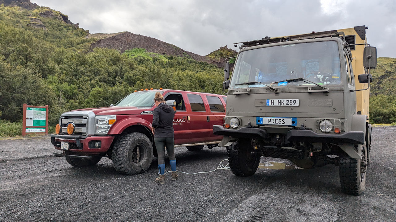 Reifendruck wird an einem roten super Jeep in Island mit einer Druckluftpistole überprüft