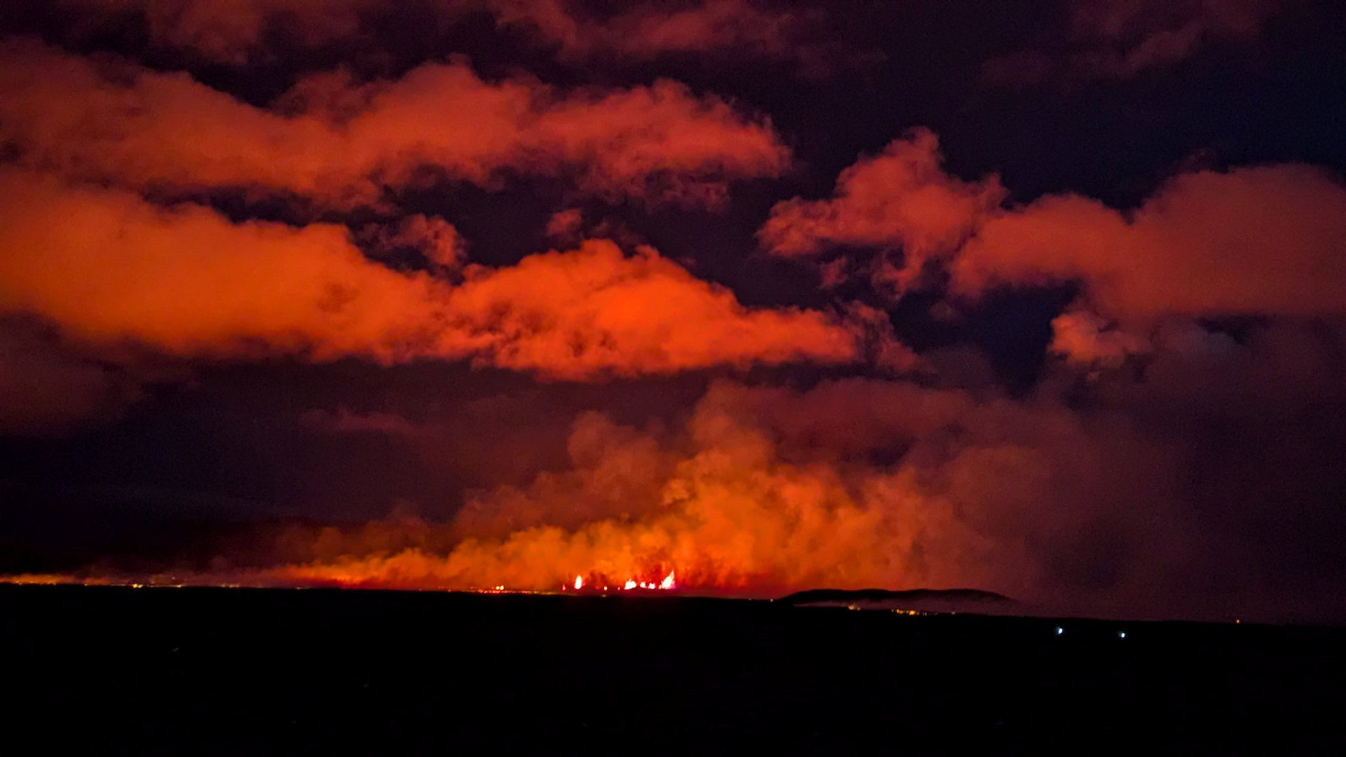 Vulkanausbruch in Island, der Nachts Wolken rot anleuchtet