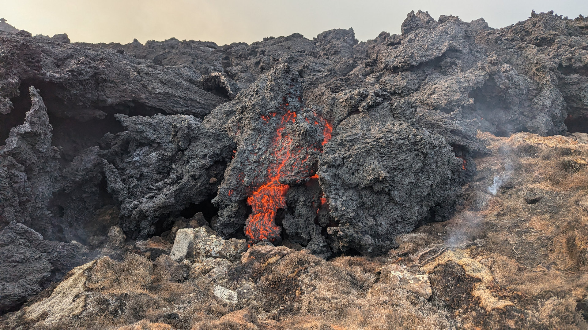 Schwarze Lava, die im inneren noch rot glüht