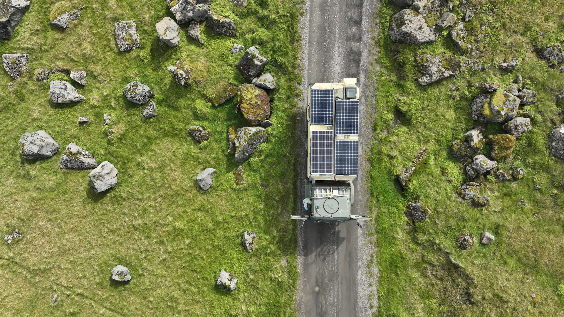 Luftbild LKW zwischen Moos bewachsenen Steinen in Island