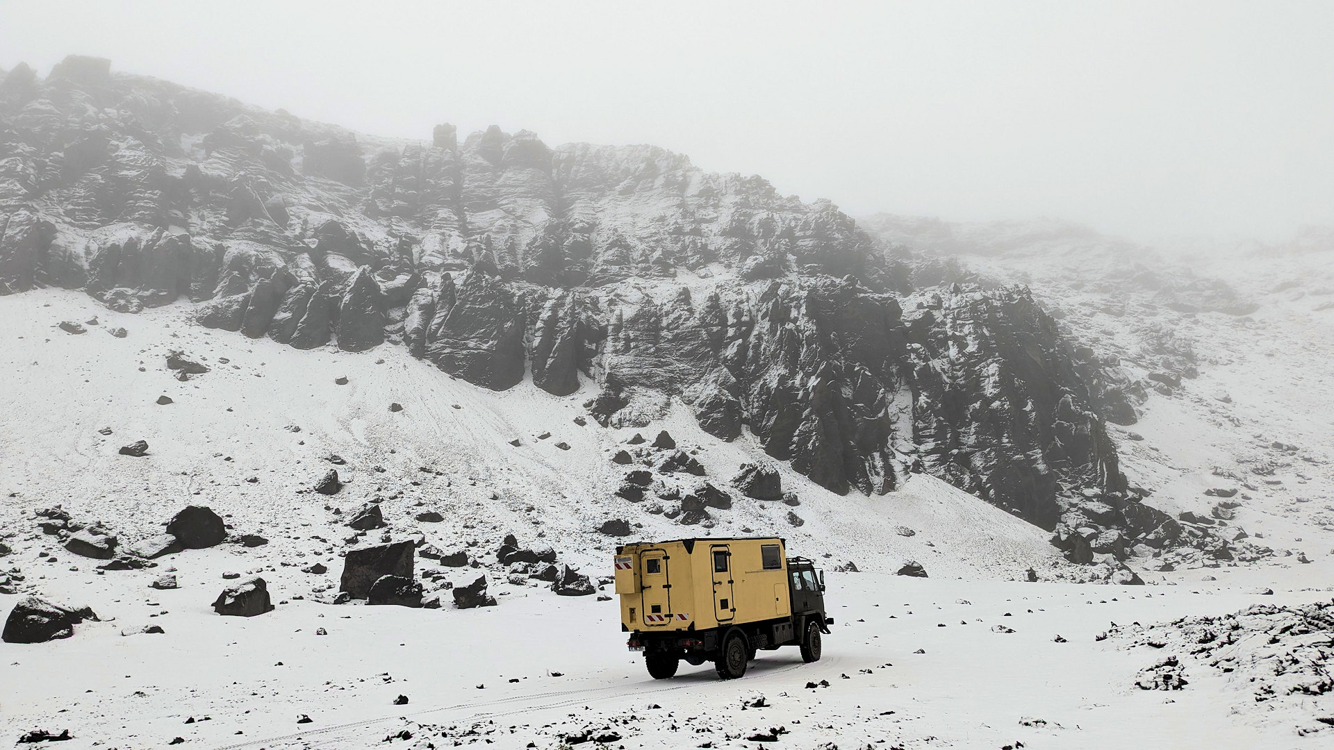 Verschneites Dyngjufjöll Gebirge in Island mit einem 4x4 LKW im Vordergrund