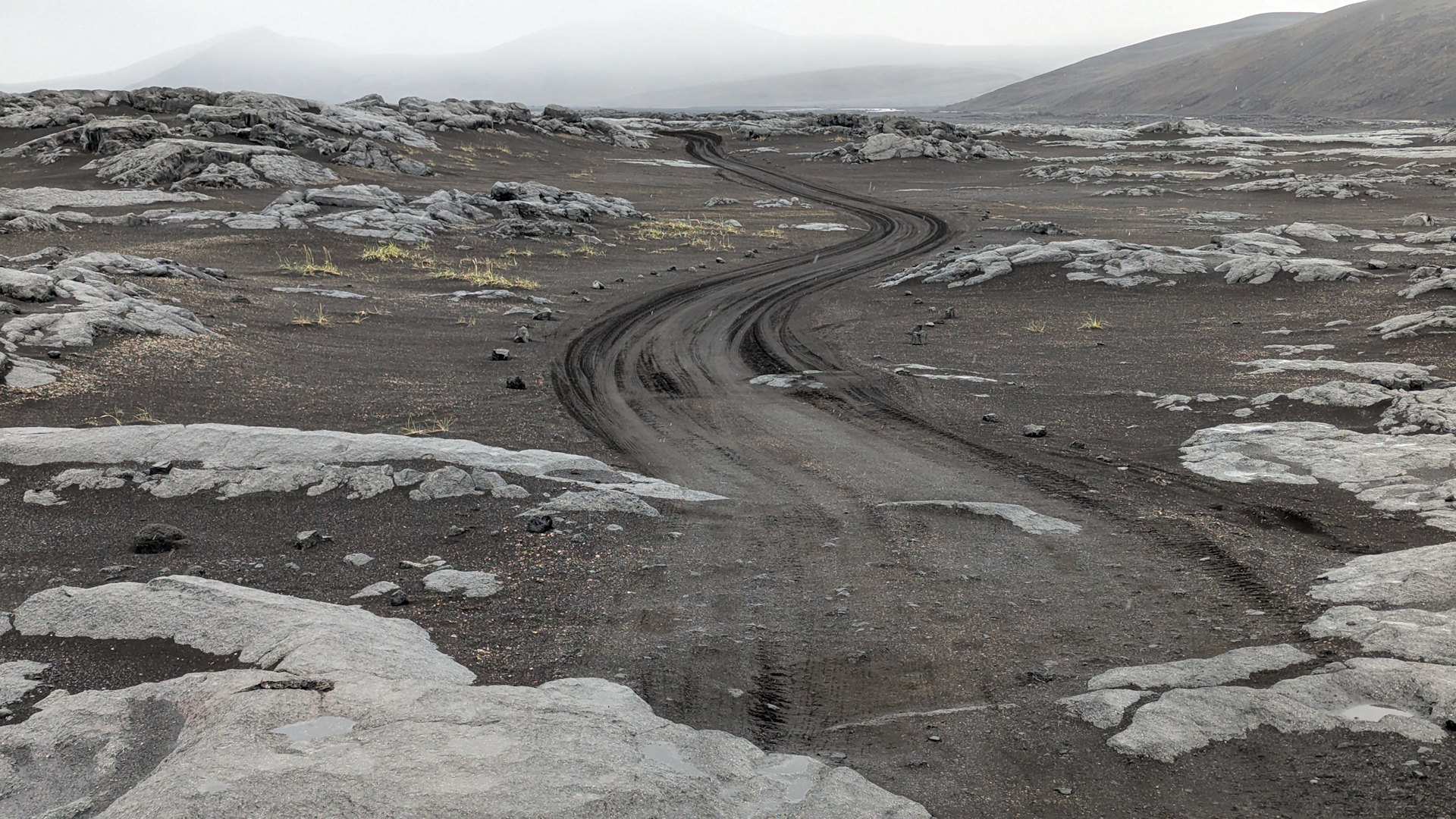 Sandpiste in Island zwischen Lava Platten