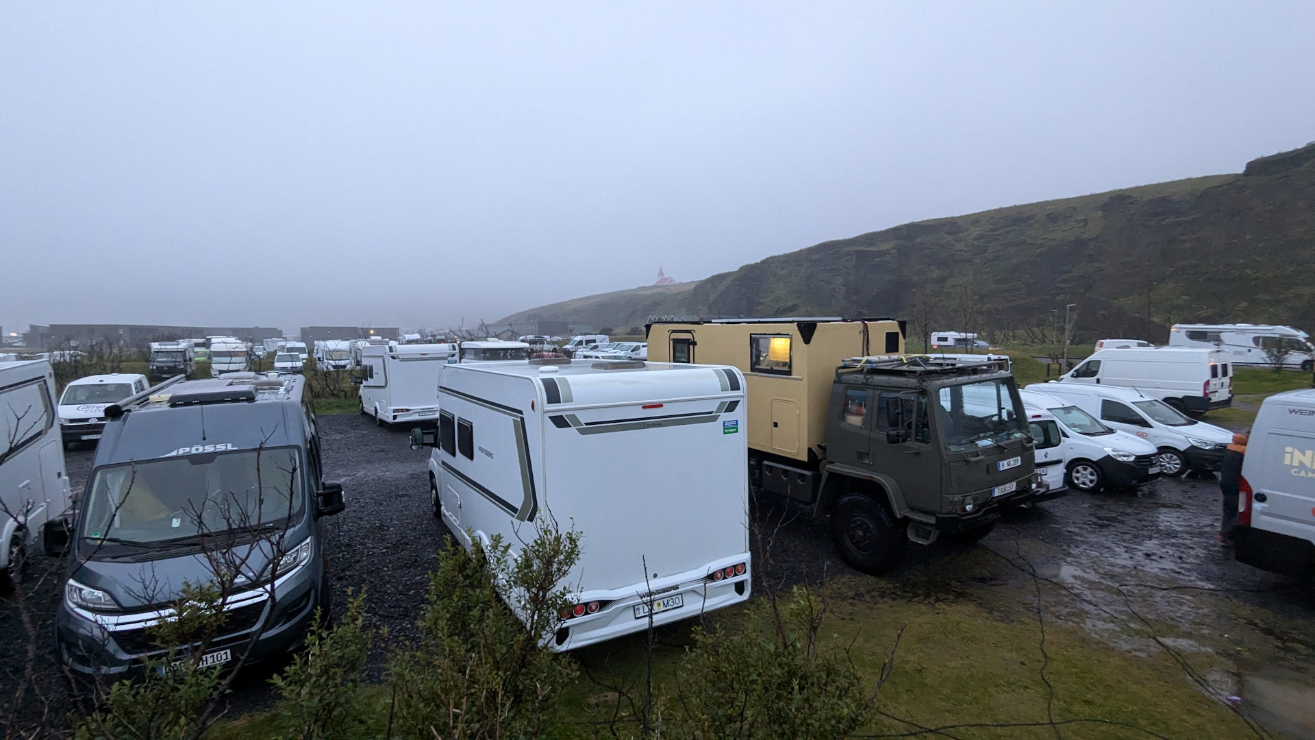 Zugeparkter Campingplatz in Vik mit unzähligen Fahrzeugen. 