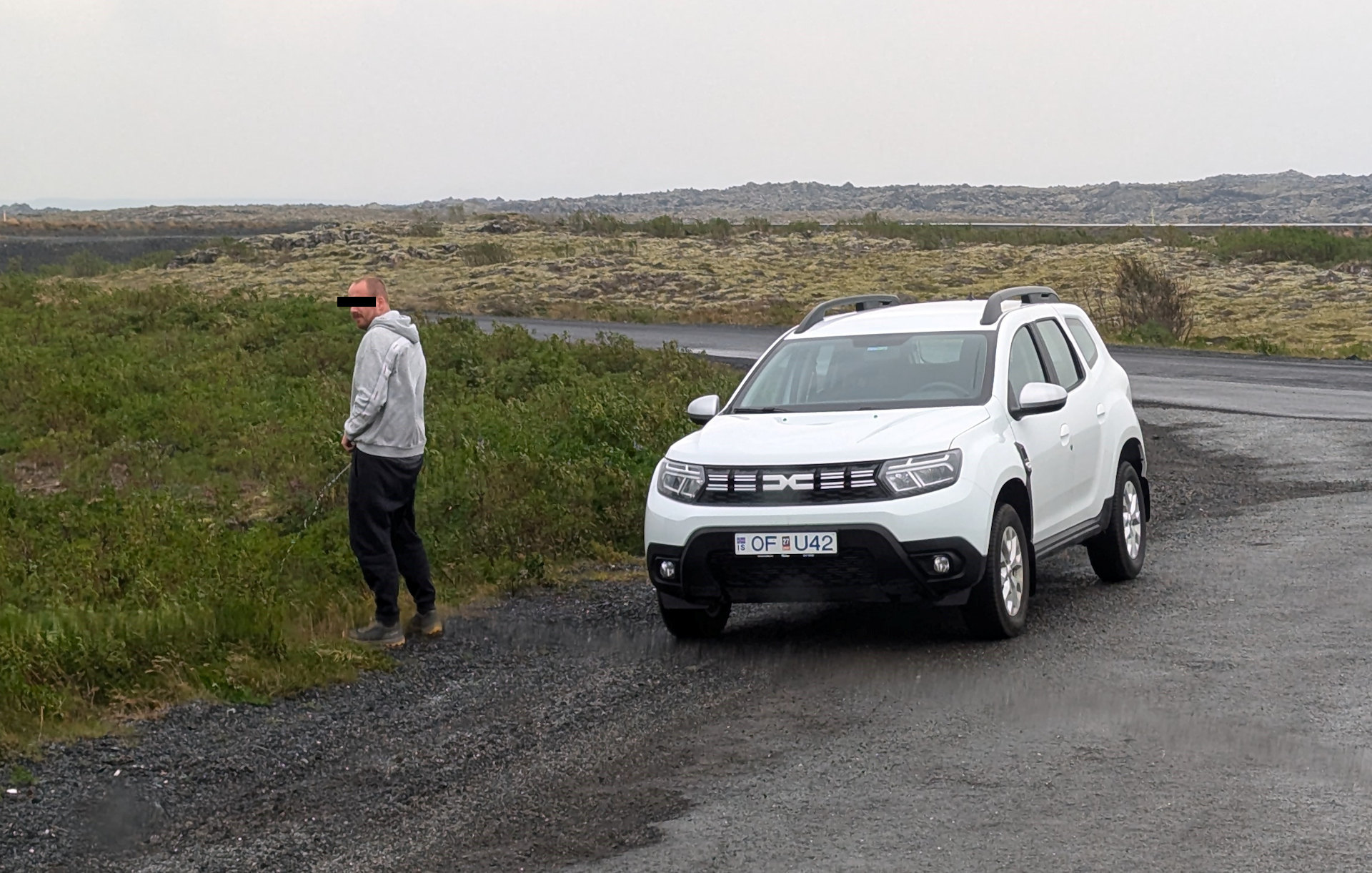 Typ beim Wild pinkeln neben einem Dacia Duster in Island