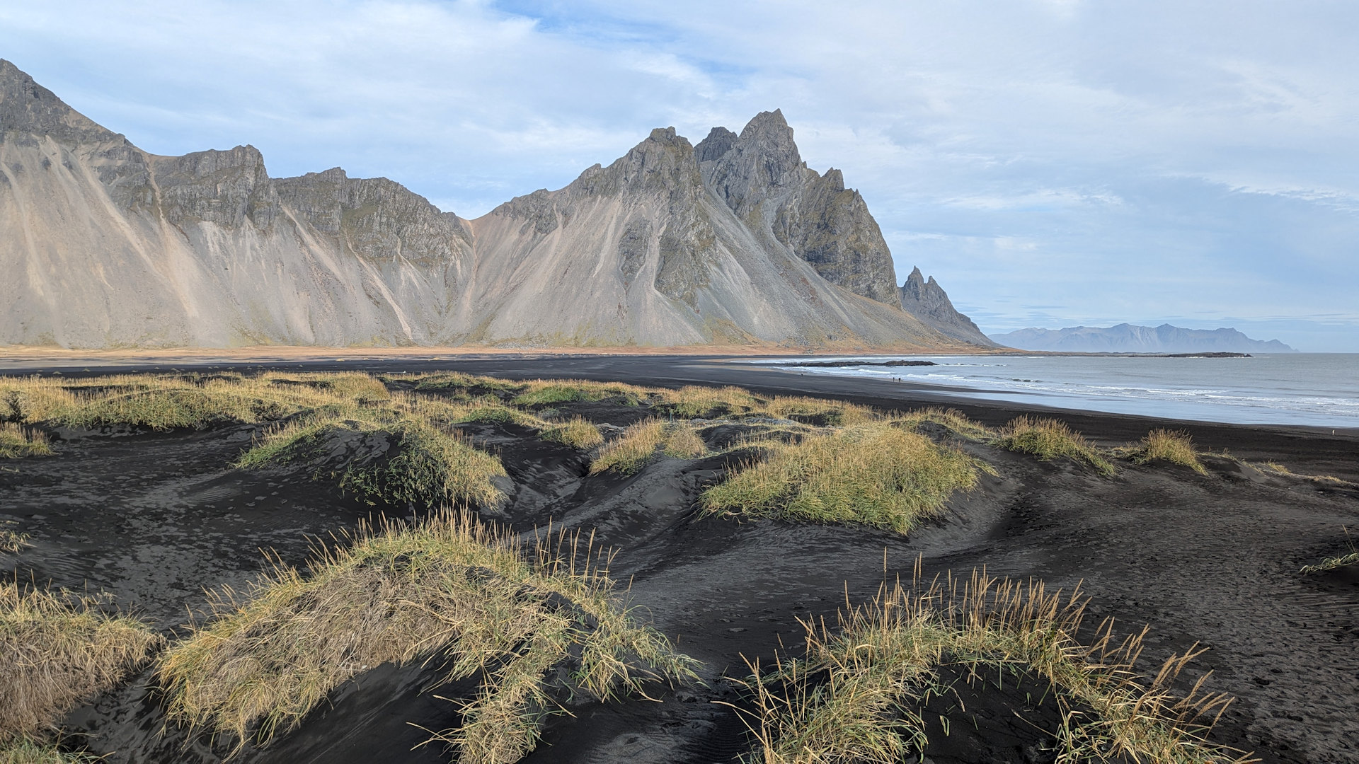 Vesturhorn Island mit Inseln aus Gras am schwarzen Strand